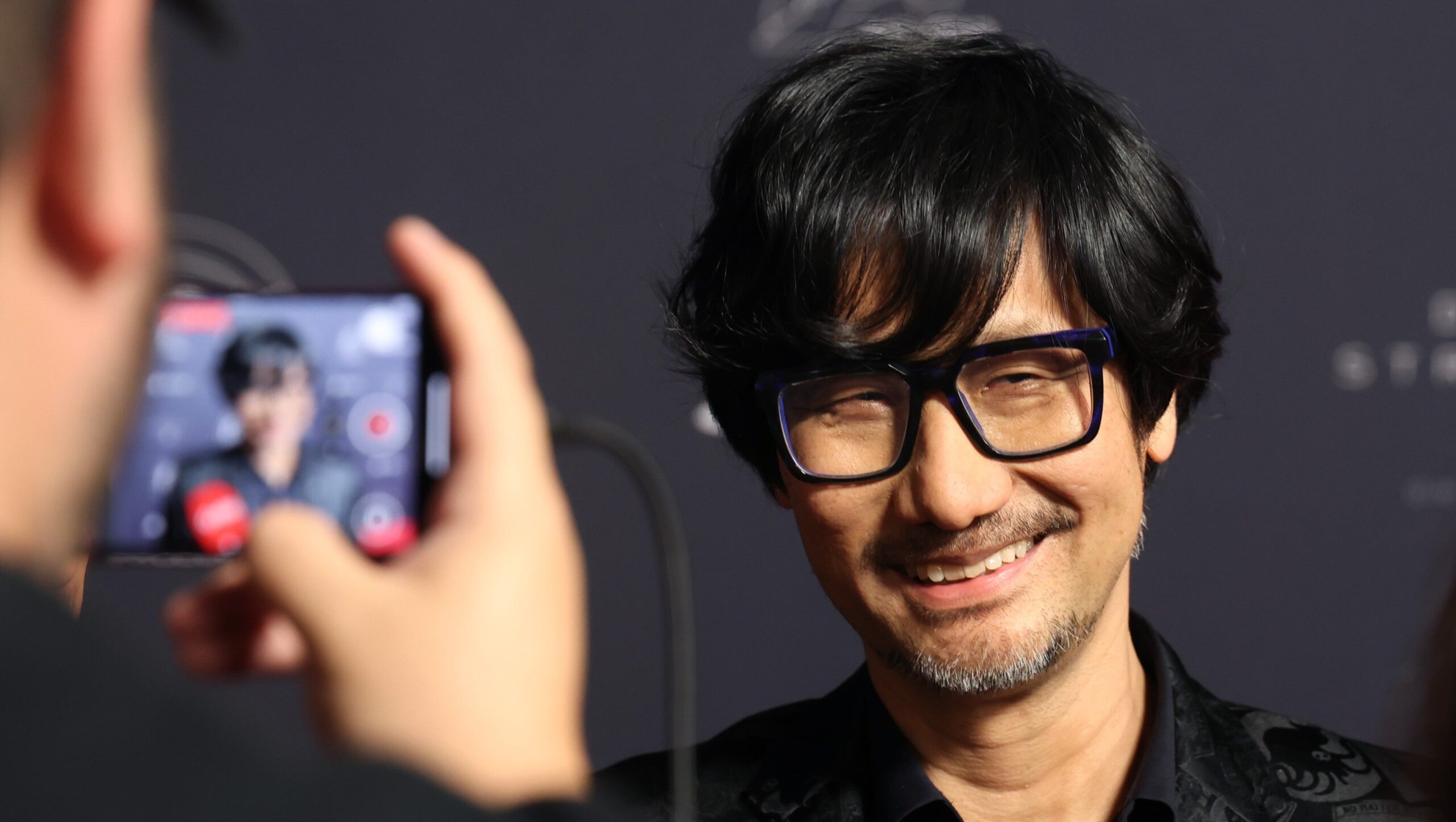 Hideo Kojima Wears Joy Division T-Shirt to Sony Visit, Sparking Johnny Silverhand Arasaka Tower Comparison